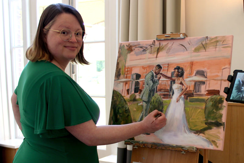 Artist paints a portrait of a wedding couple.